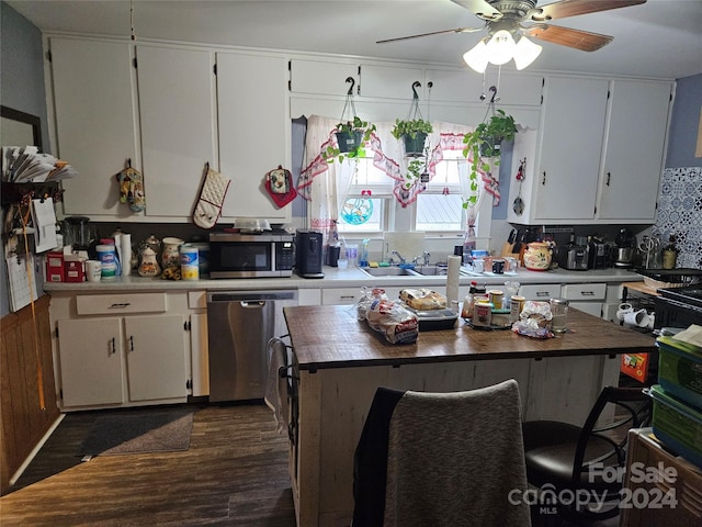 kitchen with white cabinetry, stainless steel appliances, and butcher block counters