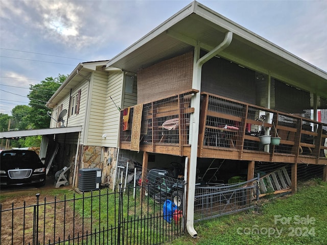 view of side of home featuring a yard and central AC