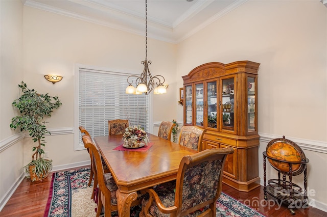 dining room with a chandelier, crown molding, and dark wood-type flooring