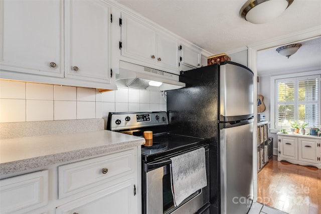 kitchen featuring appliances with stainless steel finishes, light hardwood / wood-style flooring, white cabinets, and decorative backsplash