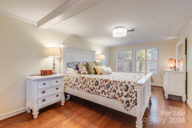 bedroom featuring beam ceiling, ornamental molding, and wood-type flooring