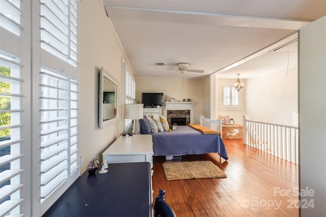 bedroom with hardwood / wood-style flooring and ceiling fan with notable chandelier