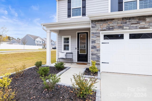 property entrance with a garage, a porch, and a lawn