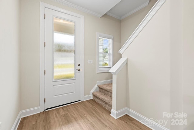 entryway with light wood-type flooring and ornamental molding