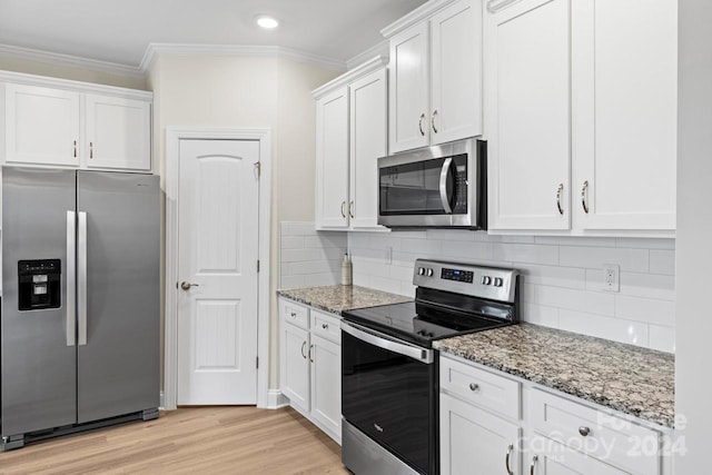 kitchen featuring white cabinetry, light wood-type flooring, stainless steel appliances, and light stone counters