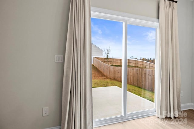 doorway to outside with hardwood / wood-style floors and a wealth of natural light