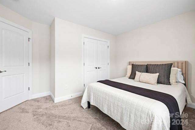 bedroom featuring a closet and light colored carpet