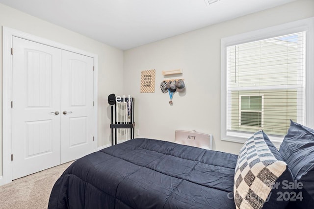 bedroom with carpet floors, multiple windows, and a closet