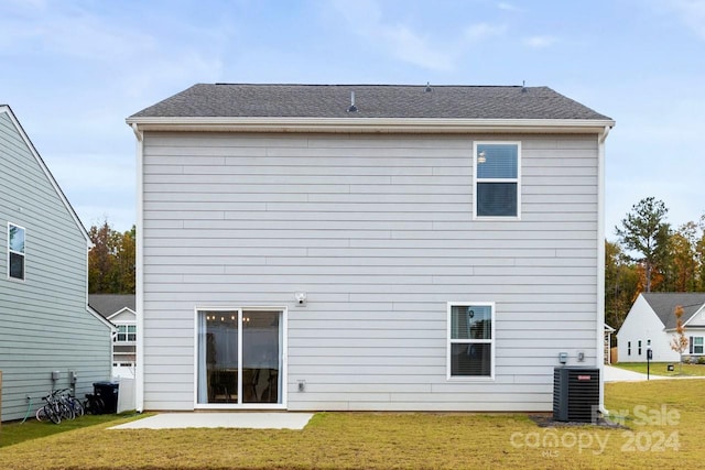 back of property with a lawn, central AC, and a patio