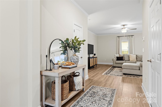 living room with ornamental molding, light hardwood / wood-style flooring, and ceiling fan