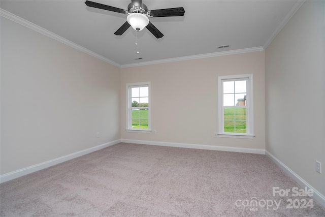 unfurnished room with ceiling fan, light colored carpet, and crown molding