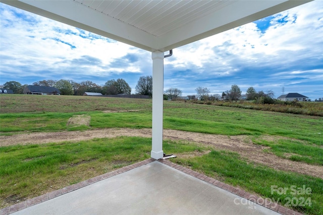 view of yard with a rural view and a patio area