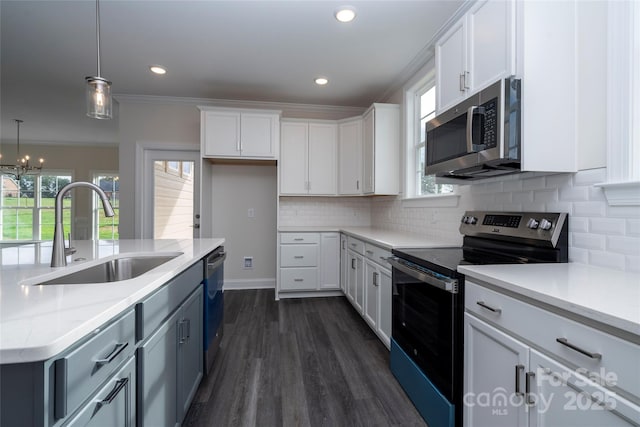 kitchen featuring ornamental molding, appliances with stainless steel finishes, a sink, and white cabinetry