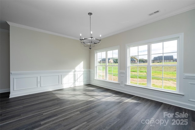 unfurnished dining area featuring dark wood-style flooring, crown molding, a notable chandelier, visible vents, and wainscoting