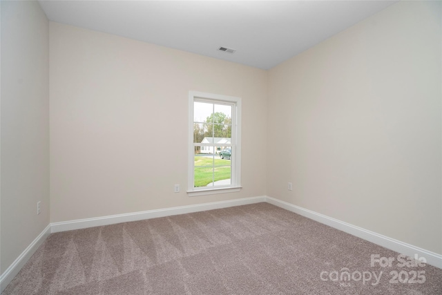 unfurnished room featuring carpet, visible vents, and baseboards