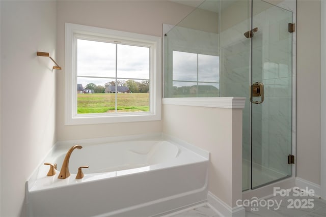 full bathroom featuring a stall shower, marble finish floor, a garden tub, and baseboards