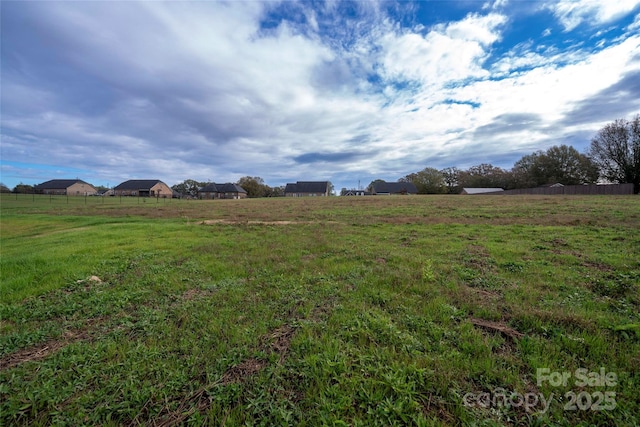 view of yard with a rural view and fence