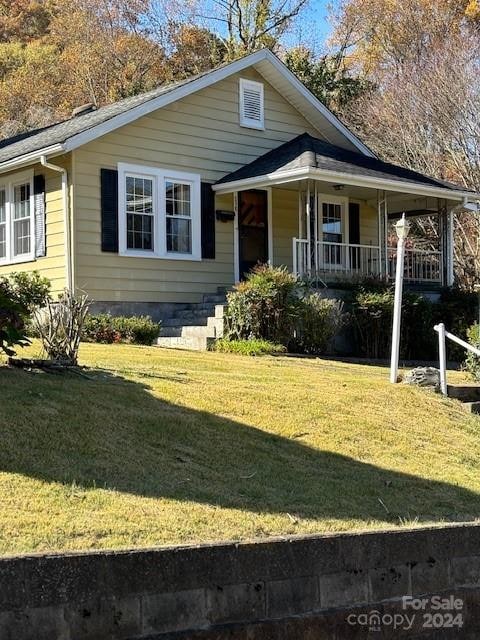 view of front of home with covered porch and a front lawn