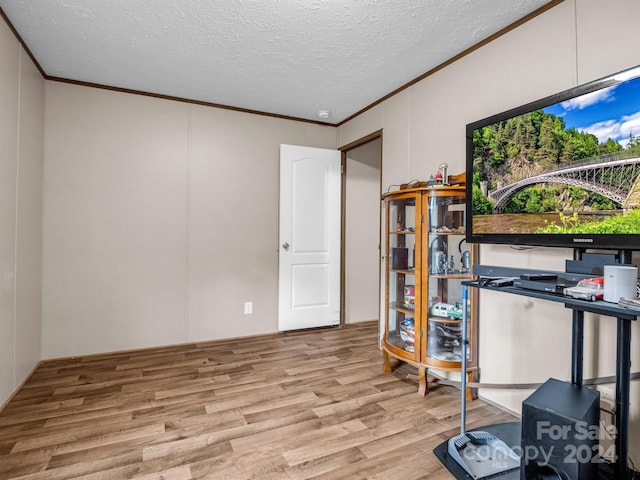 office area featuring ornamental molding, light hardwood / wood-style flooring, and a textured ceiling