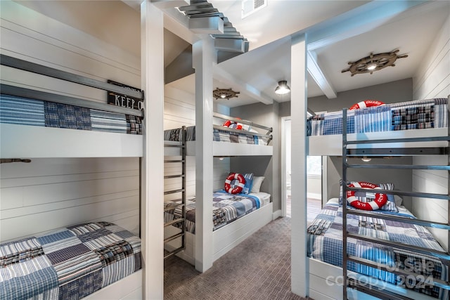 carpeted bedroom with beam ceiling