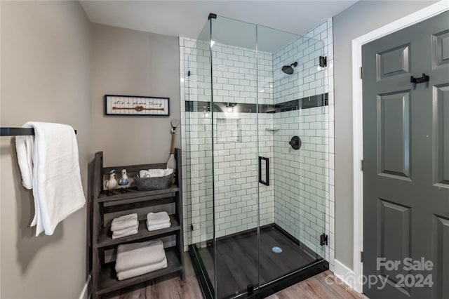 bathroom with wood-type flooring and an enclosed shower