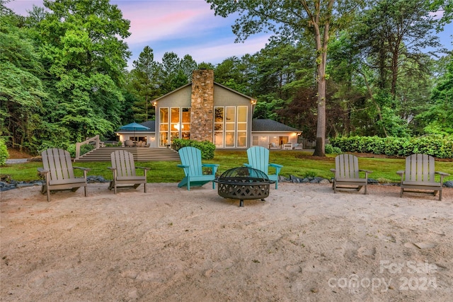 patio terrace at dusk featuring an outdoor fire pit