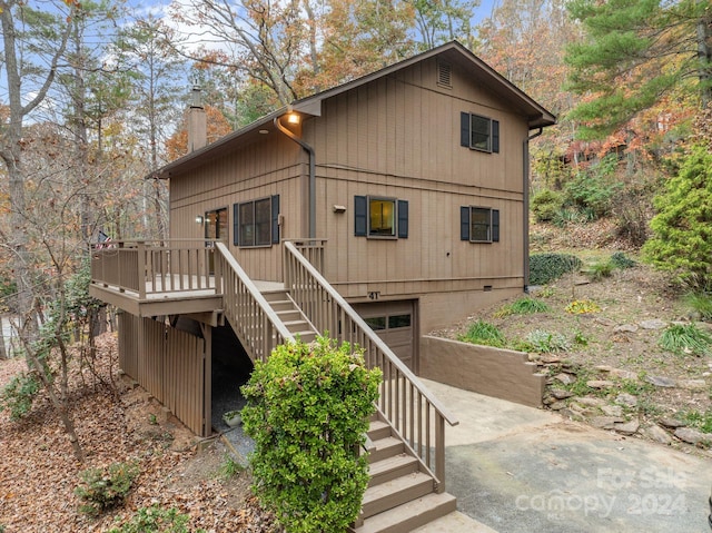 view of property exterior featuring a garage and a deck