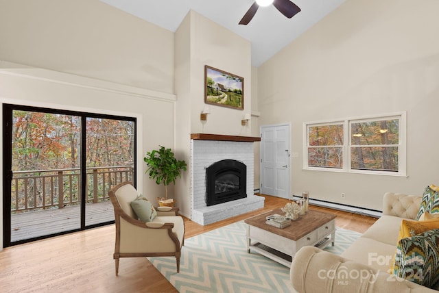 living room with a baseboard radiator, high vaulted ceiling, ceiling fan, and light hardwood / wood-style floors