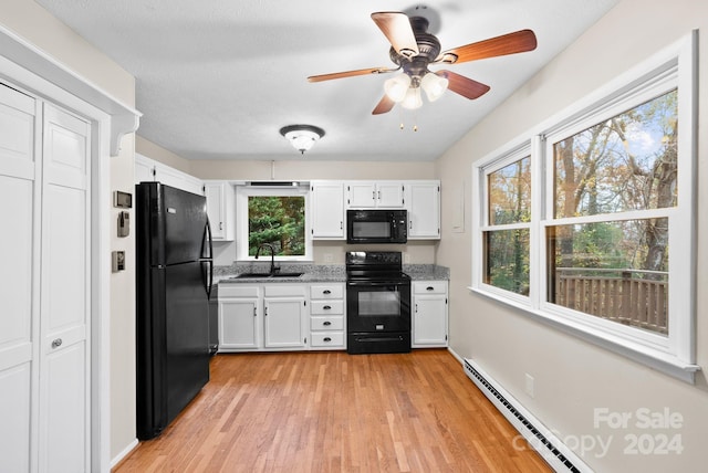 kitchen featuring black appliances, white cabinetry, sink, and a wealth of natural light