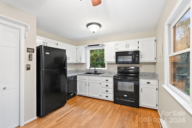 kitchen with white cabinetry, sink, black appliances, and light hardwood / wood-style floors