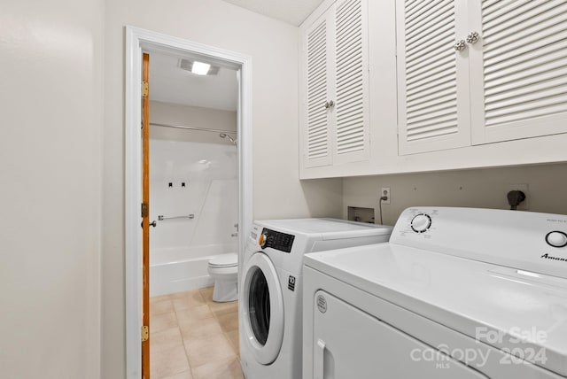 laundry area with cabinets, light tile patterned floors, and washer and dryer