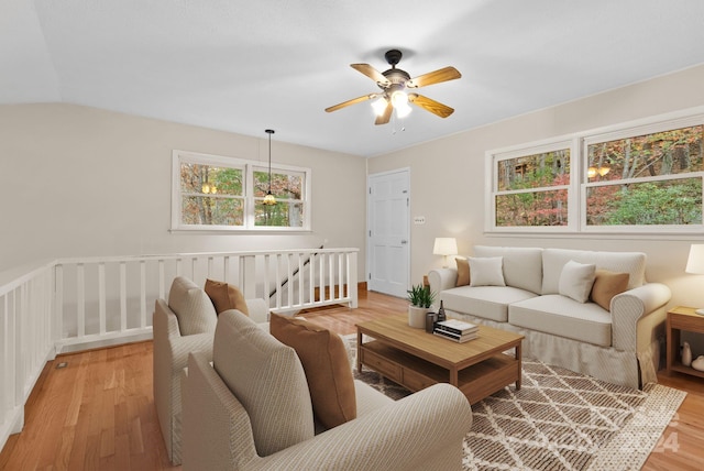 living room with ceiling fan, light hardwood / wood-style flooring, and lofted ceiling