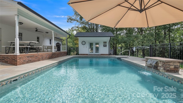 view of pool with pool water feature, a patio, and an outdoor structure