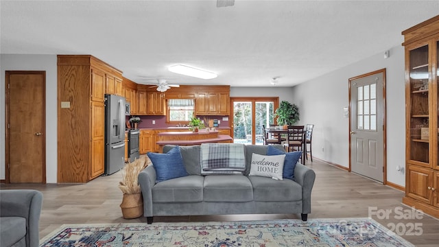 living room with ceiling fan and light hardwood / wood-style flooring