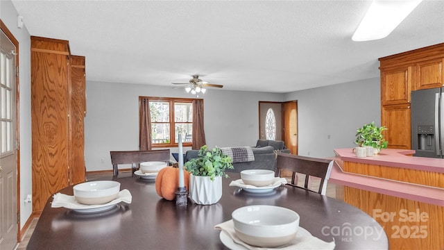 dining room featuring ceiling fan and a textured ceiling