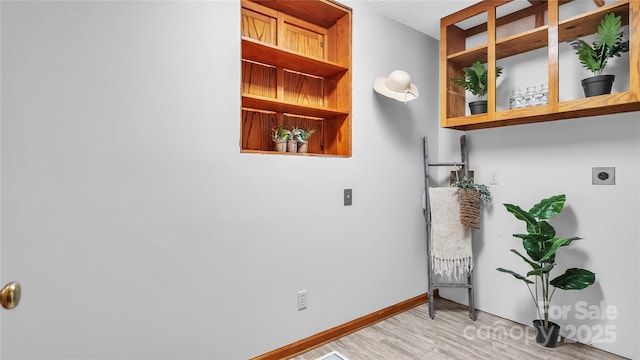 laundry area with hookup for an electric dryer and light wood-type flooring