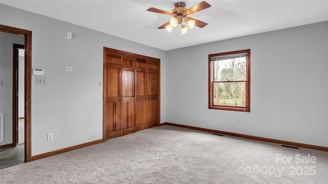 unfurnished bedroom with ceiling fan, a closet, and carpet