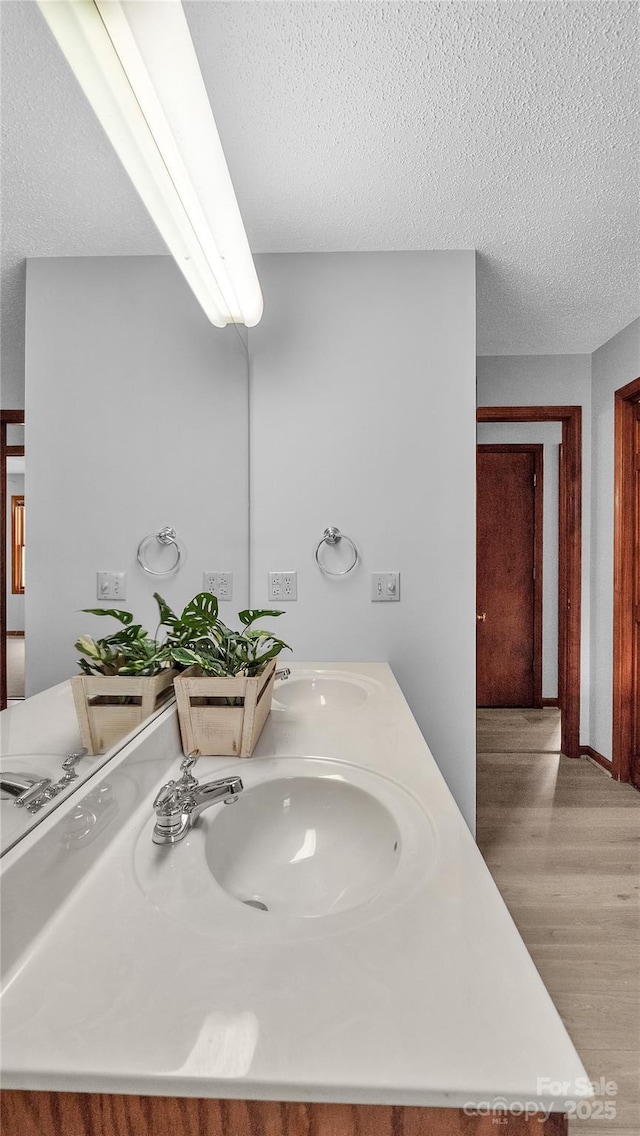 bathroom featuring vanity, wood-type flooring, and a textured ceiling