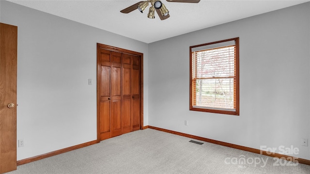 unfurnished bedroom featuring ceiling fan, a closet, and light carpet