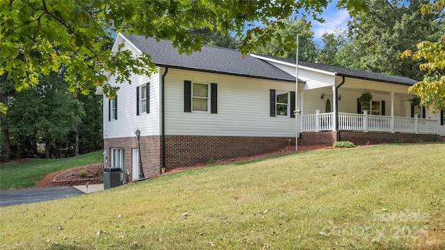 ranch-style house with central air condition unit, a front lawn, and a porch