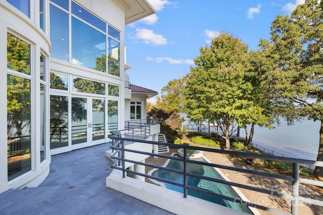 view of patio / terrace featuring french doors and a water view