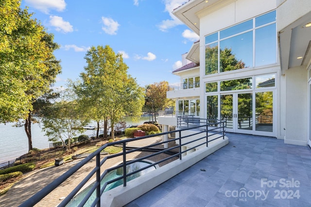 view of patio / terrace featuring a water view and a balcony