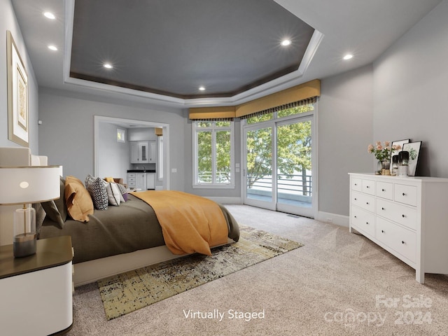 carpeted bedroom featuring access to outside and a raised ceiling