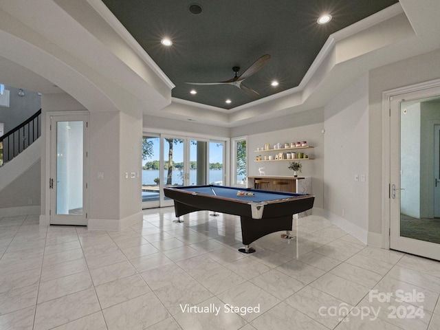 rec room featuring pool table, ceiling fan, a raised ceiling, french doors, and a water view