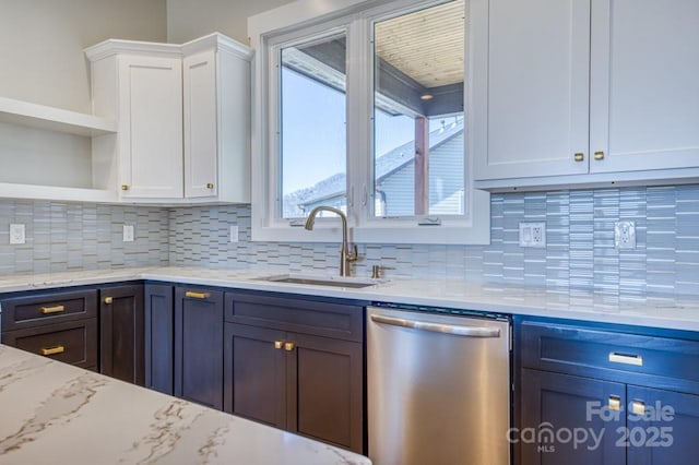 kitchen featuring backsplash, dishwasher, sink, light stone countertops, and white cabinets