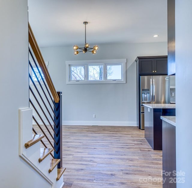 entryway with light wood-type flooring and a notable chandelier