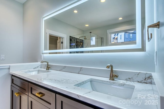 bathroom featuring a shower with door and vanity