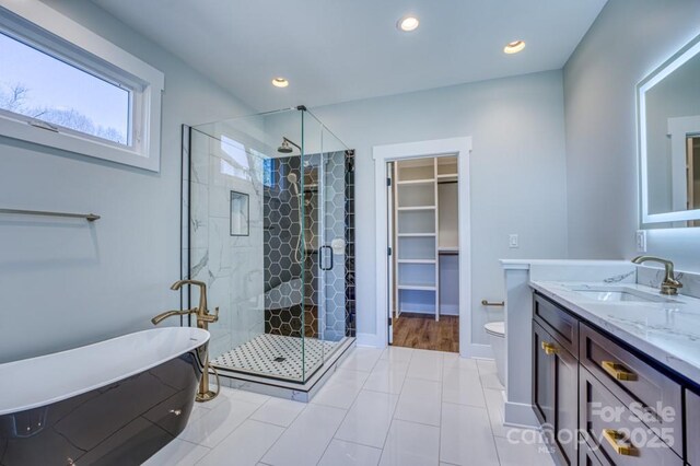 full bathroom with plus walk in shower, toilet, tile patterned flooring, and vanity