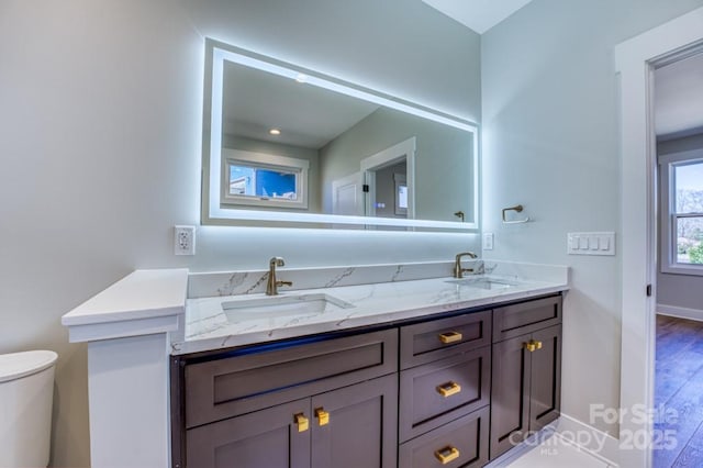 bathroom with toilet, hardwood / wood-style flooring, and vanity