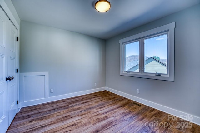 spare room featuring wood-type flooring